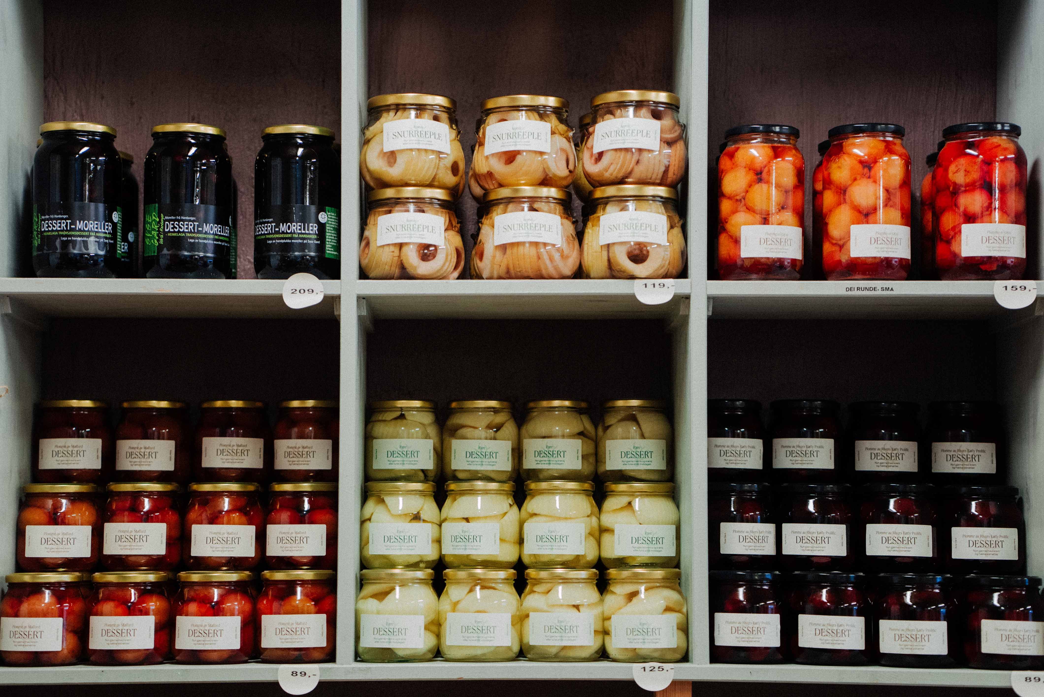 Hylle med hermetisert frukt frå Syse Gard, klar for sal i gardsbutikken.