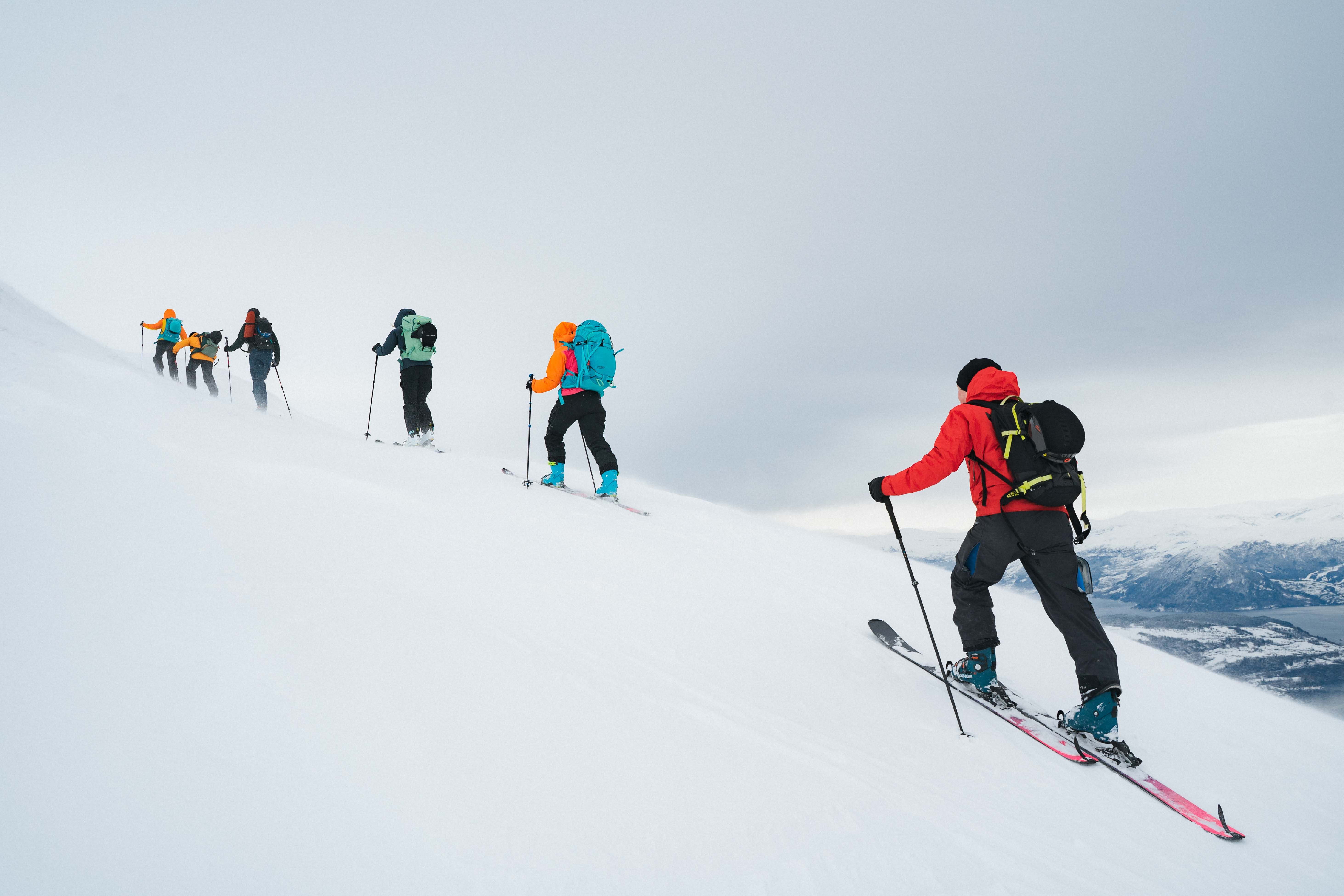 Seks personer som går på randonee/topptur.