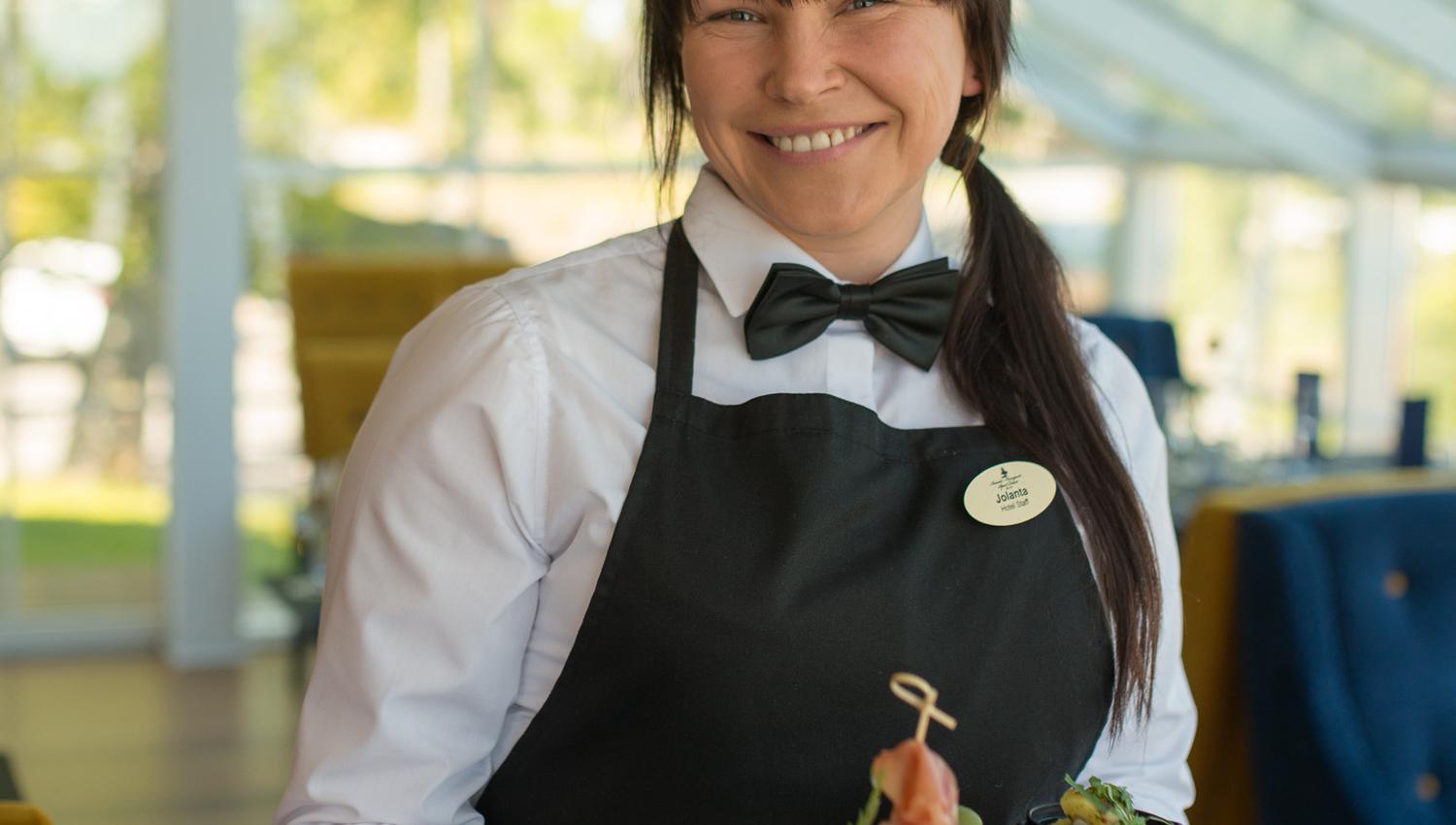 smilende servitør på hotellets restaurant