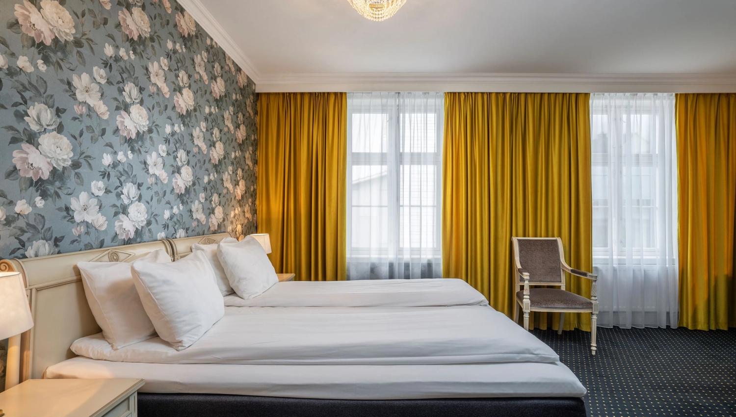 Lyst og romsleg hotellrom på Thon Hotel Sandven, med eksklusivt interiør og sjarmerande detaljer.