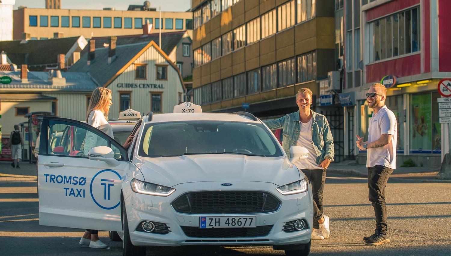 Reisende gjester på tur inn i taxi.