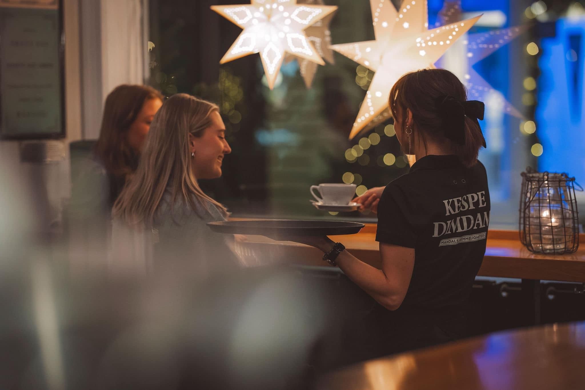 Servitør hos SMOI som serverer kaffe til gjester