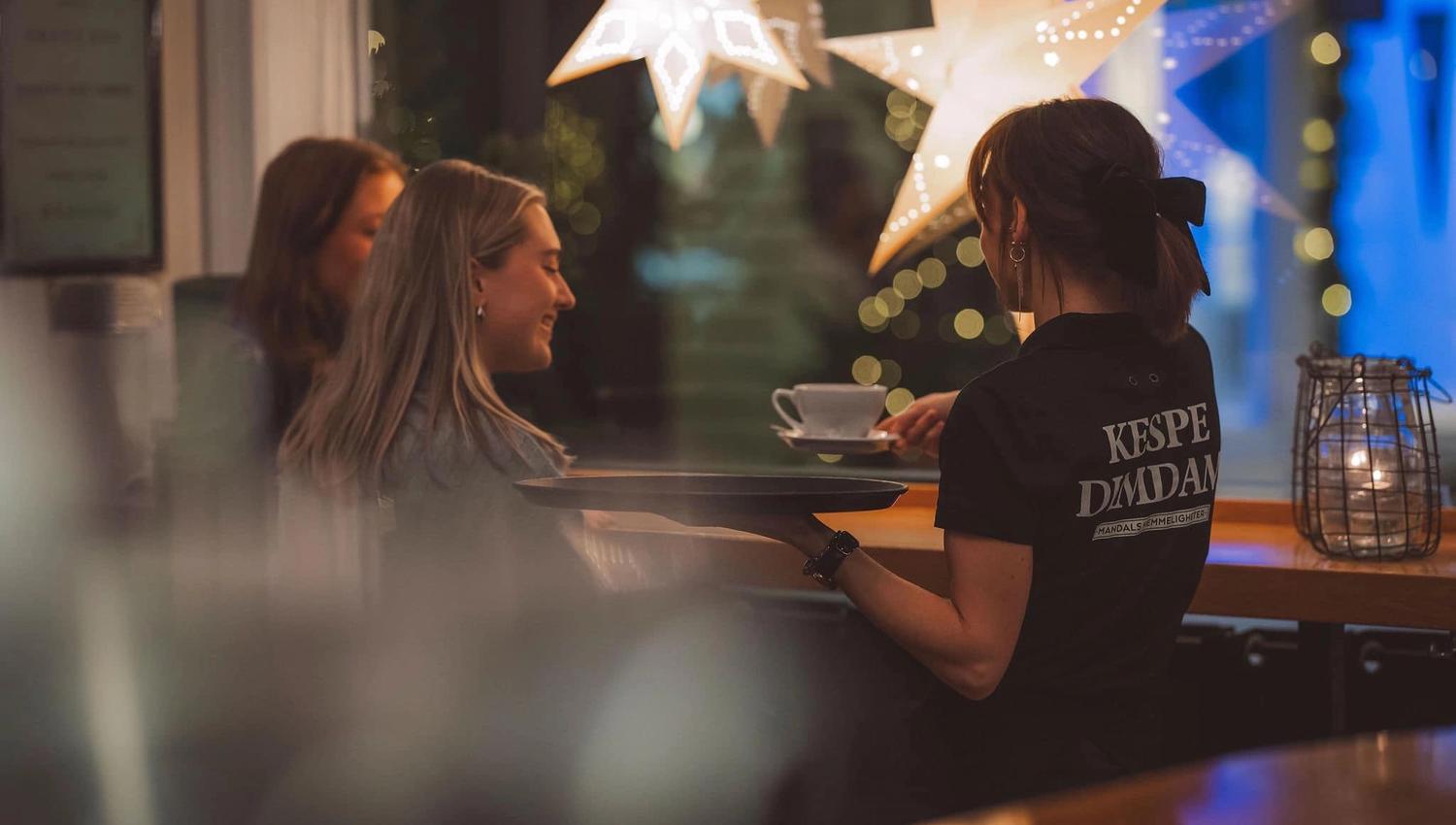 Servitør hos SMOI som serverer kaffe til gjester
