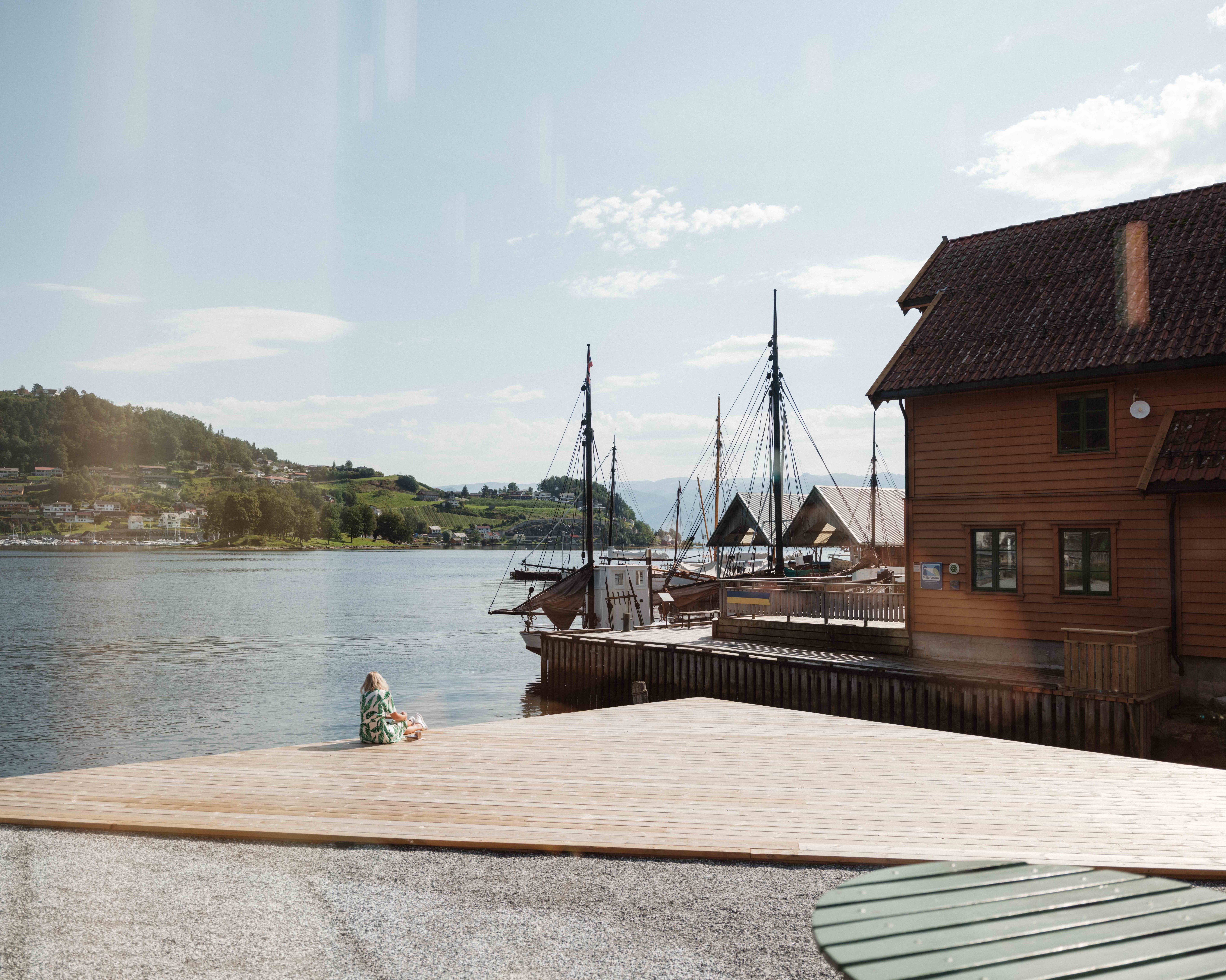 Peaceful moment by the fjord at the Hardanger Maritime Centre, overlooking historic boats and boathouses.