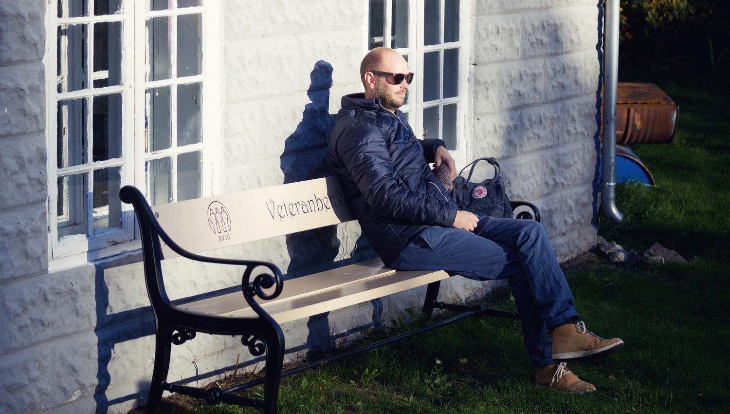 en mann som sitter på en benk
