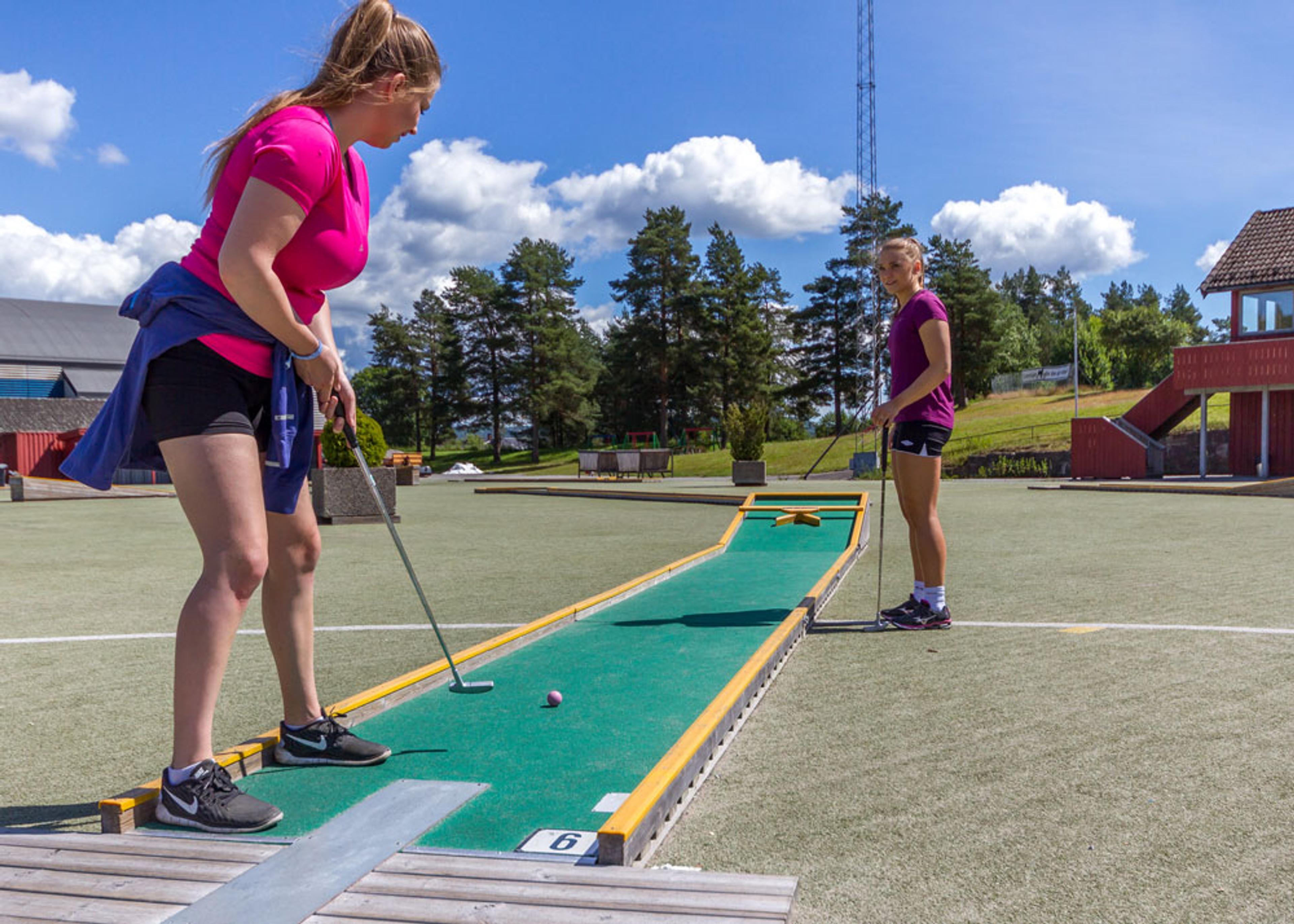 jenter spiller minigolf i Skien fritidspark