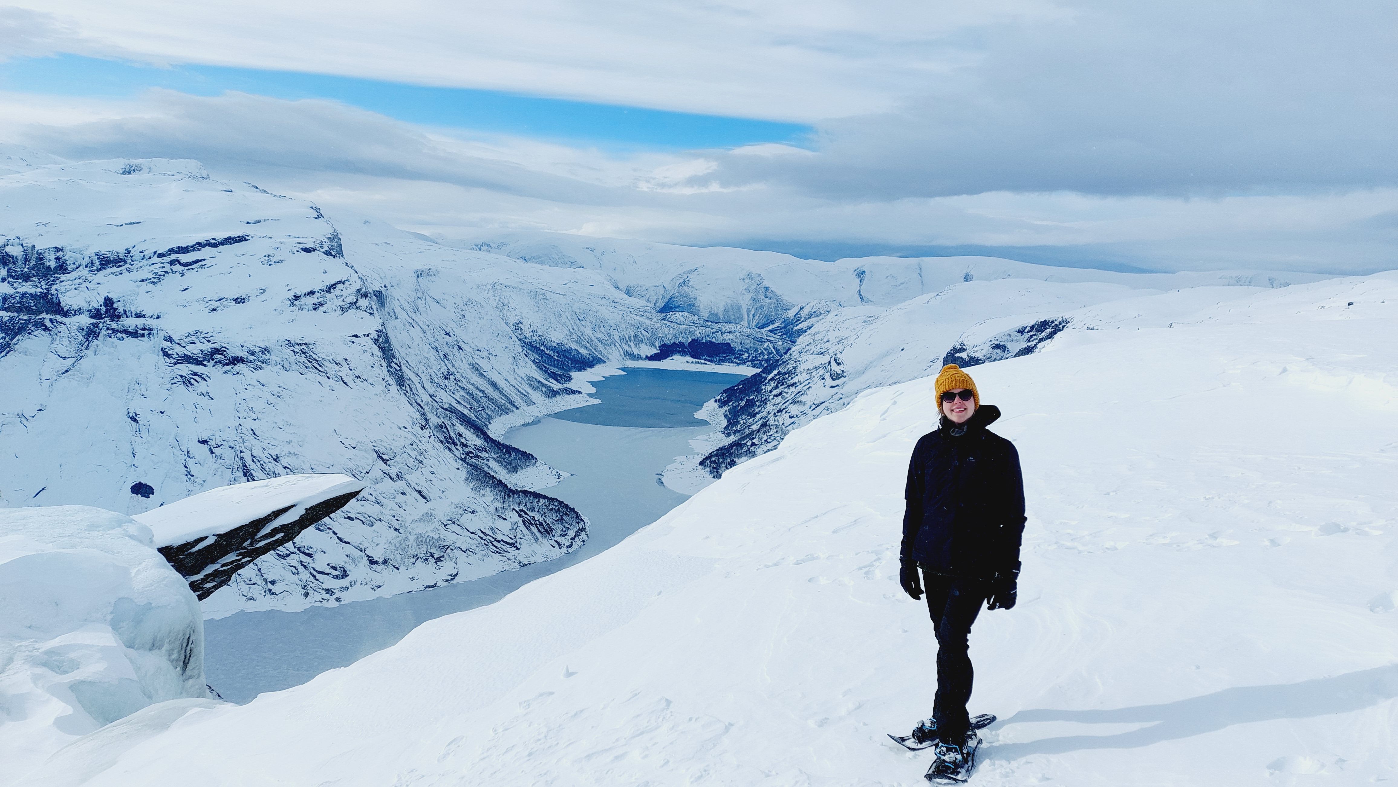 Turgåar med gul hue står ved utsiktspunktet nær Trolltunga om vinteren.