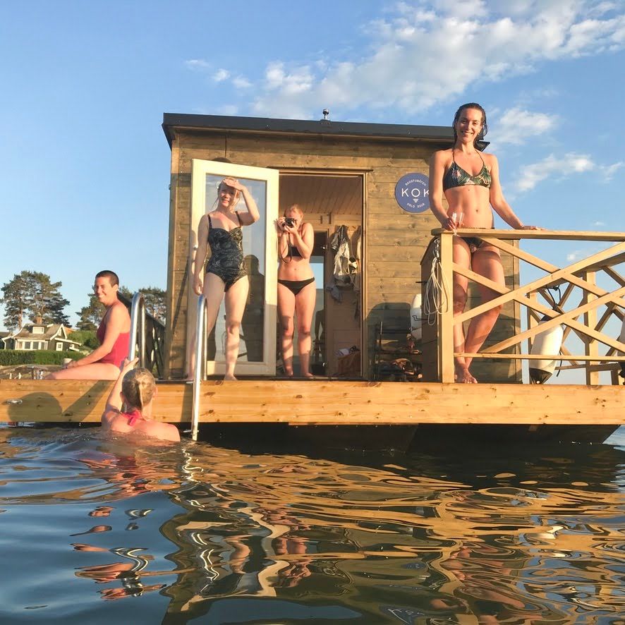 Flytende badstue på vannet med mennesker.