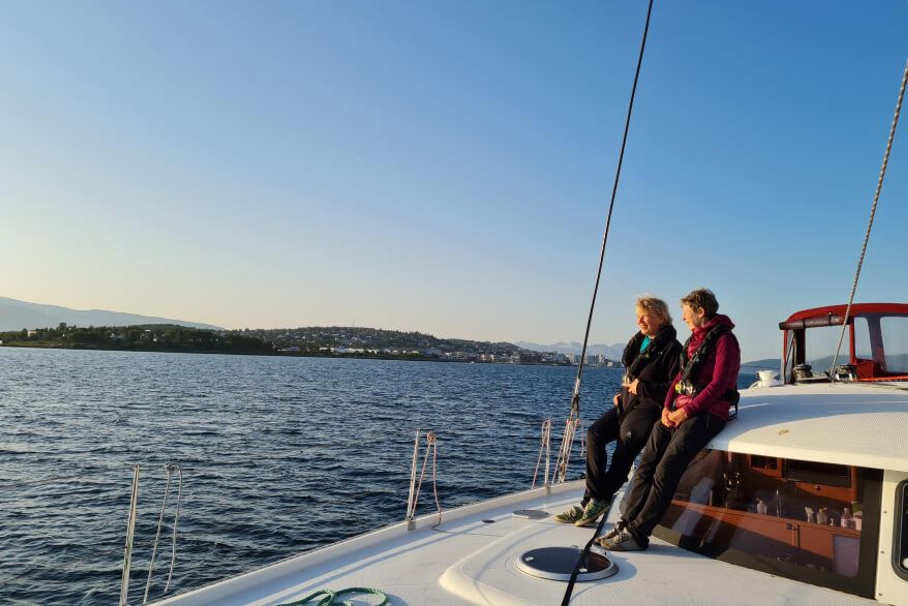 To personer på dekk på katamaranen til Northern Yachting