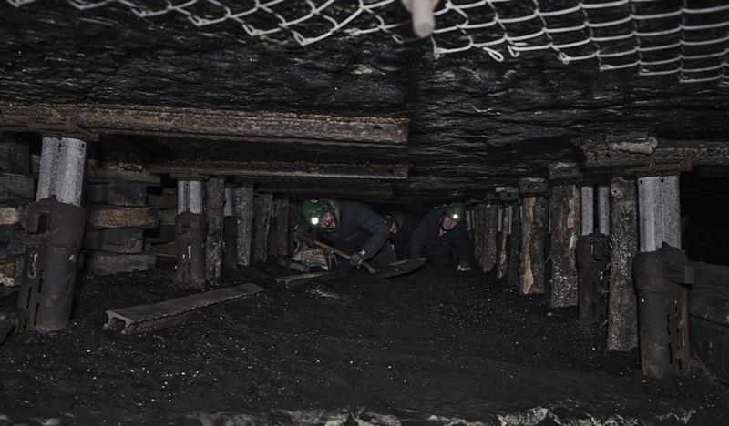 Guests on a guided tour of Mine 3 with helmets on that have gotten the chance to crawl through the mine tunnels where miners worked in the past