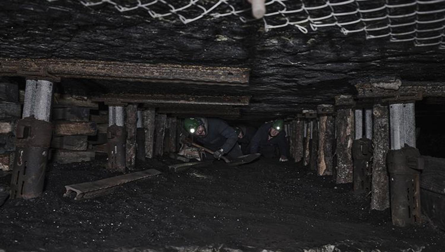 Guests on a guided tour of Mine 3 with helmets on that have gotten the chance to crawl through the mine tunnels where miners worked in the past