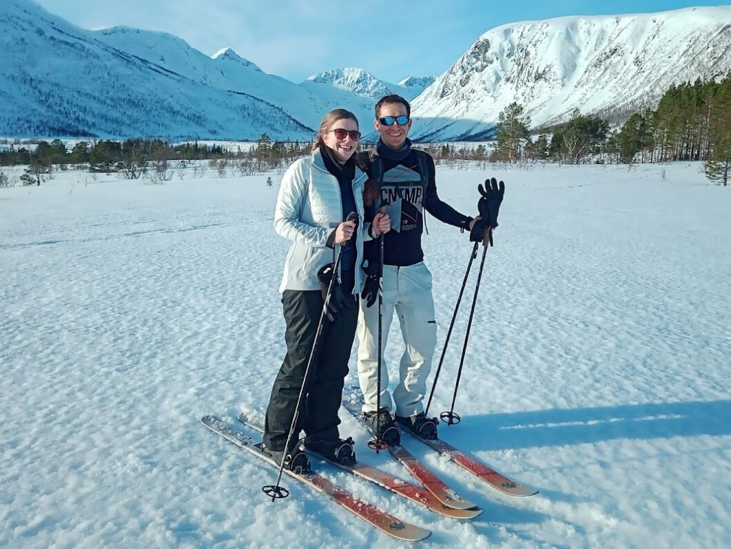 A couple pose for a photo in front of the mountains