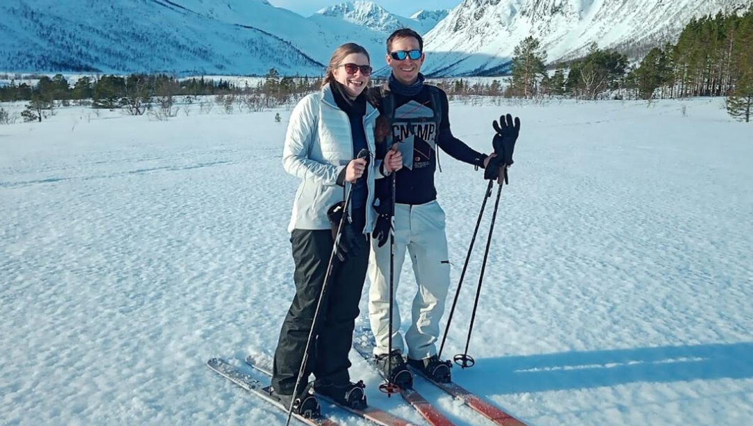 A couple pose for a photo in front of the mountains