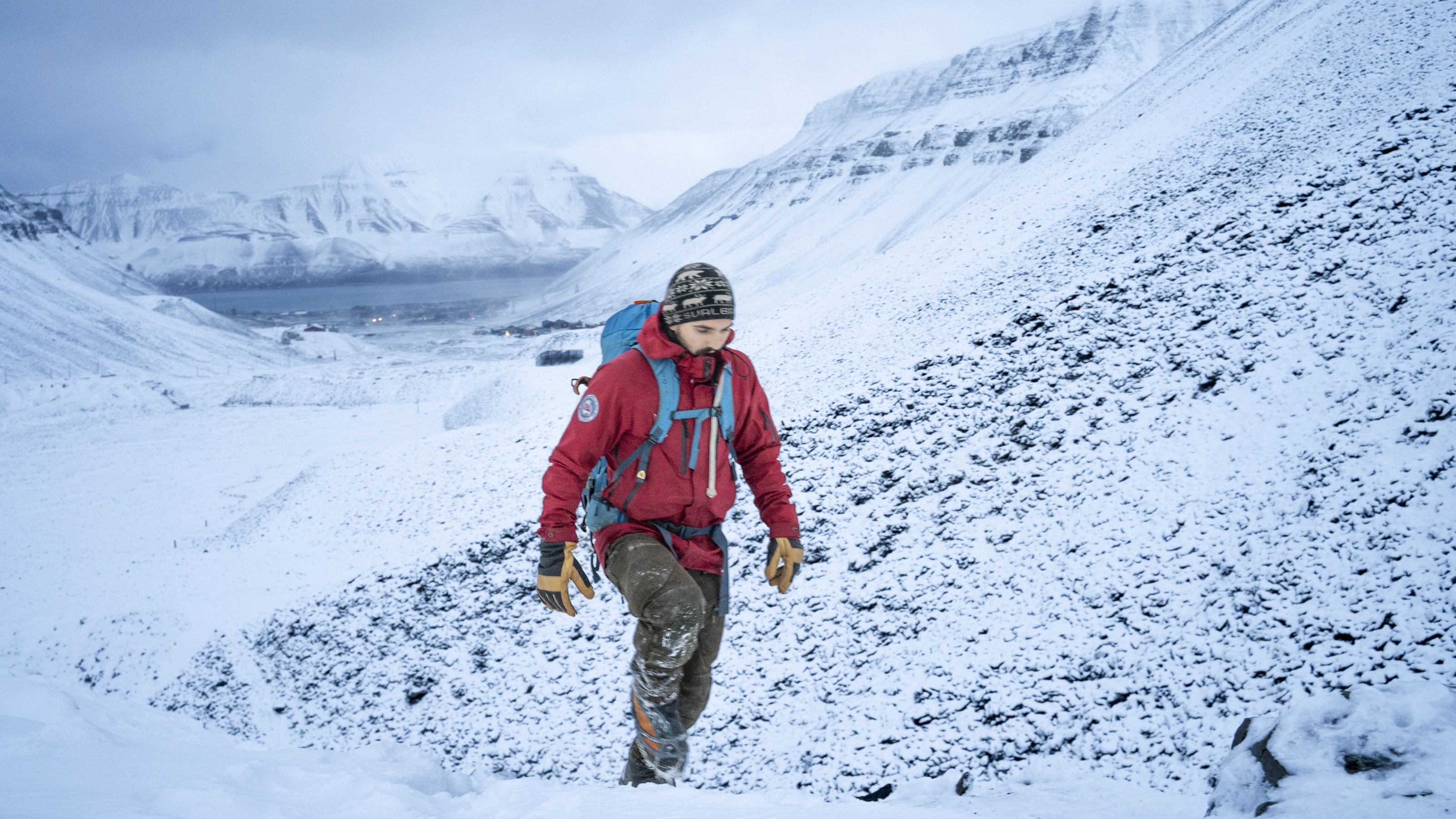 A person walking up a mountain in the winter.