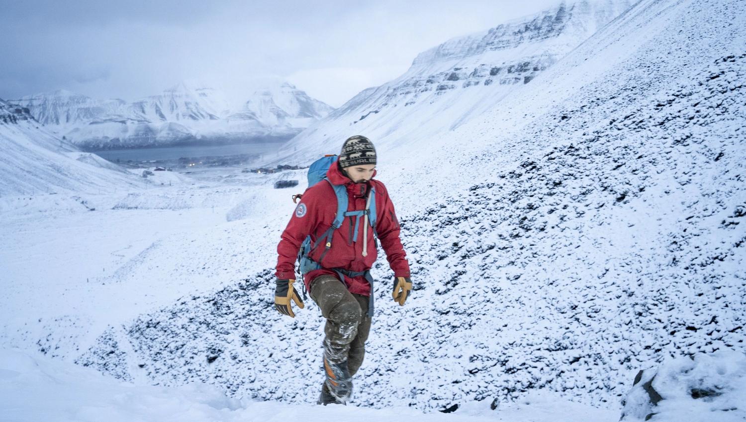 A person walking up a mountain in the winter.