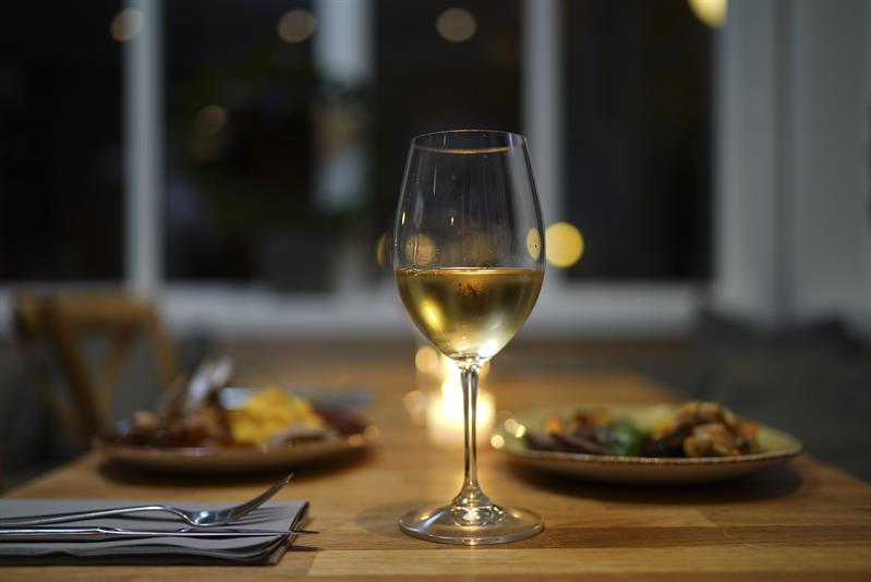 Vin i glass og mat på tallerken.