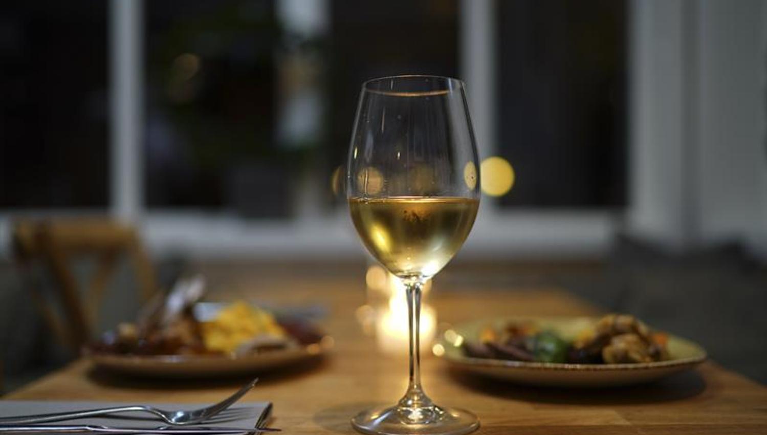 Vin i glass og mat på tallerken.