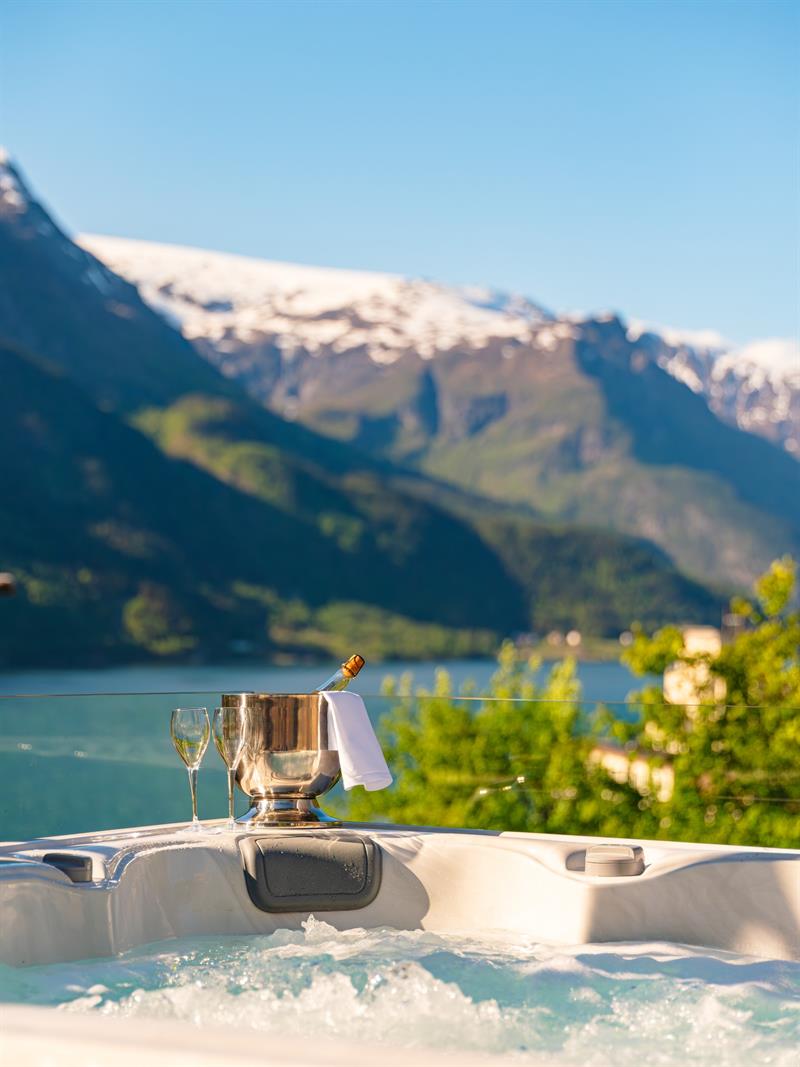 Utandørs boblebad på Tyssedal Hotel med utsikt over Hardangerfjorden.