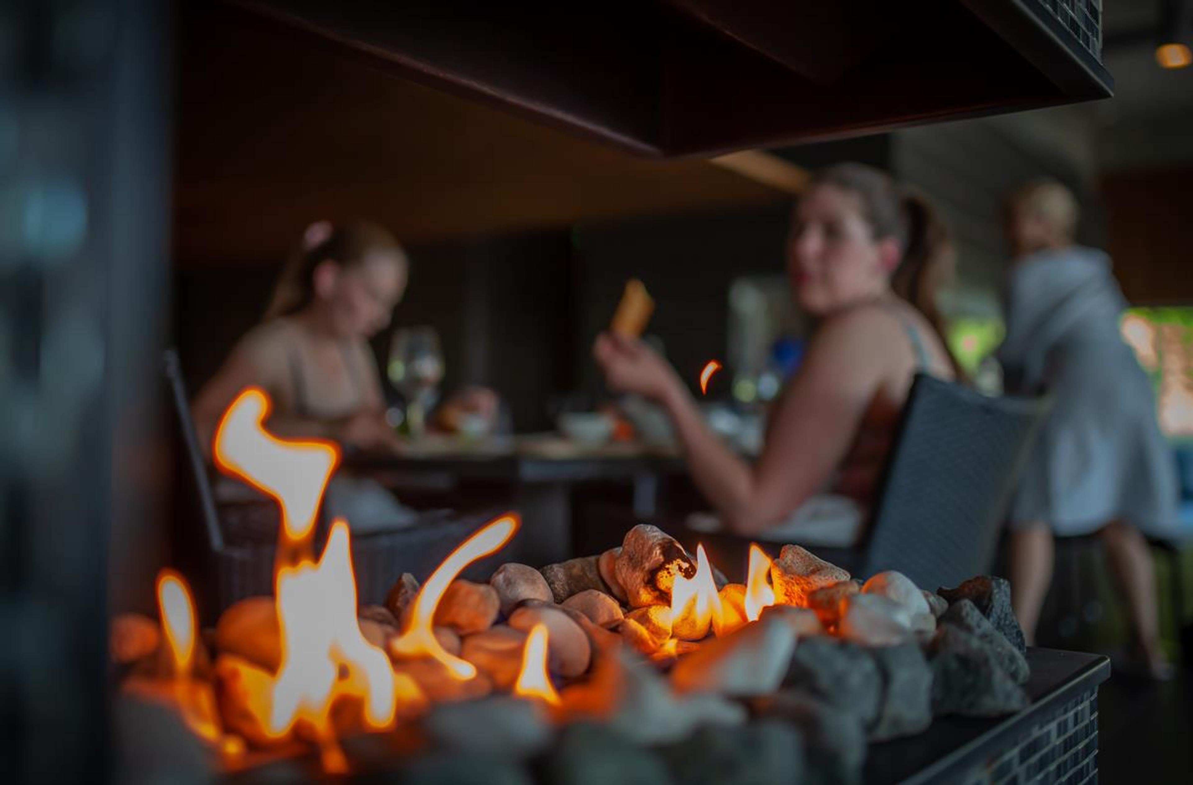 People eating in spa-area. Alive flame