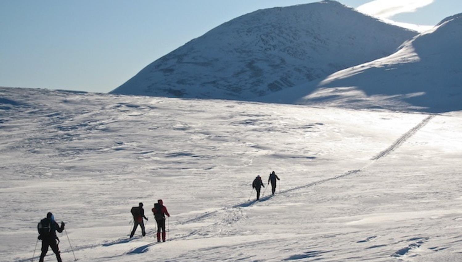 Topptur bilde fra avstand, med mennesker som går oppover i fjellet