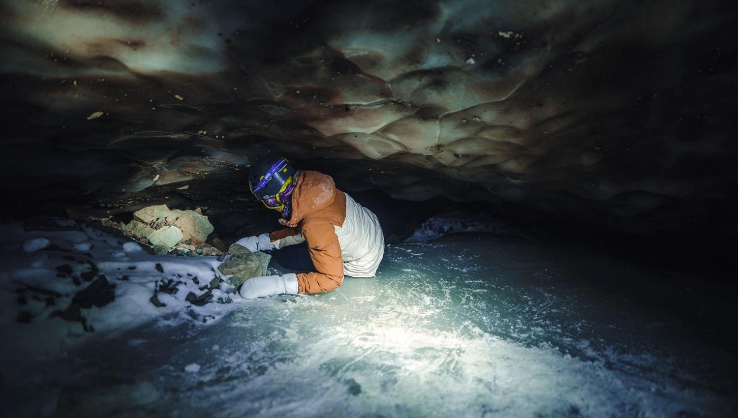 A person is crawling inside a ice cave