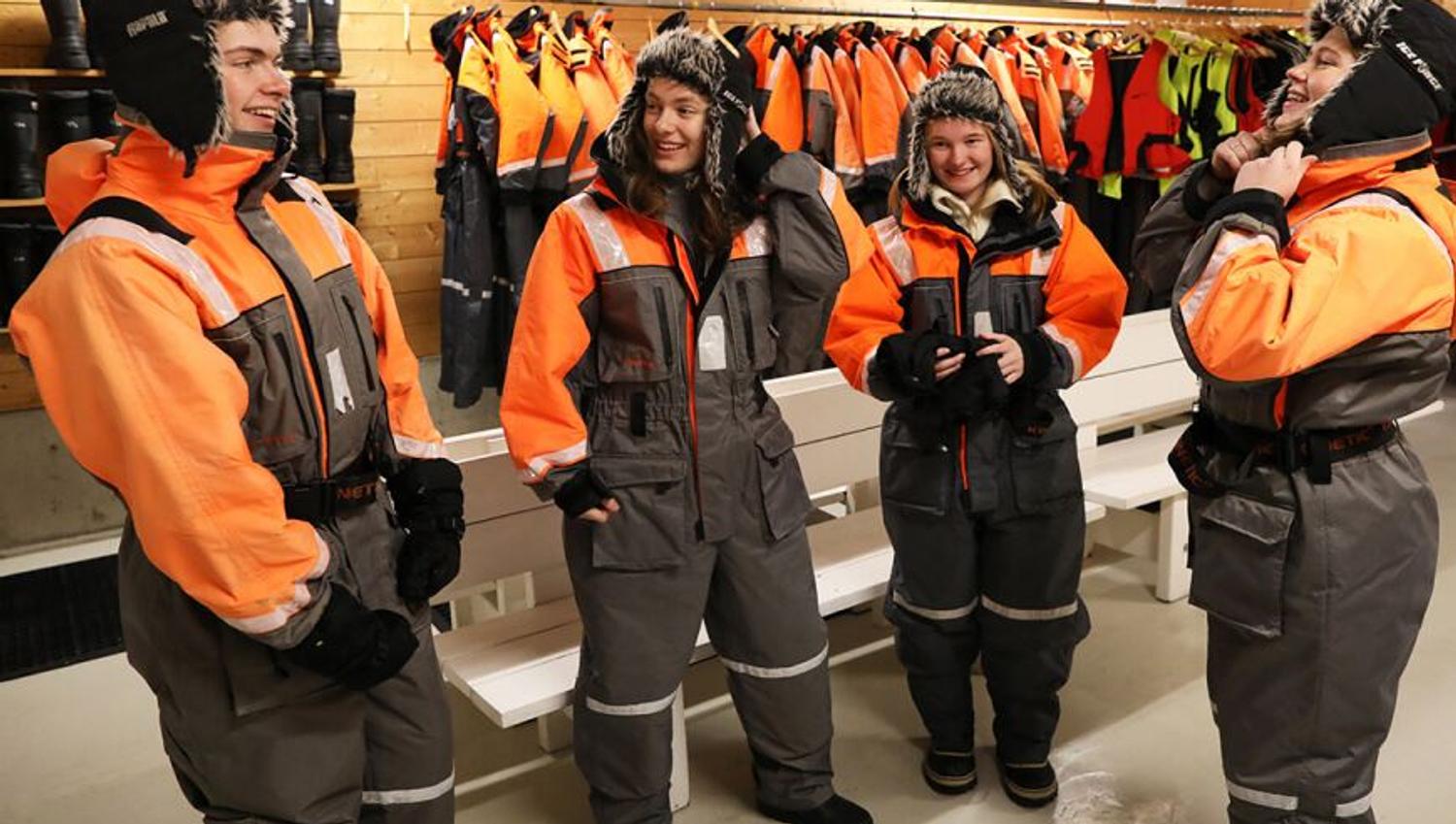 Group getting ready with floatation suits for a fishing trip with Explore the Arctic
