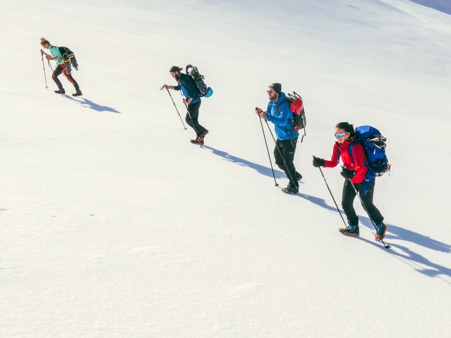 Group ascending a snowy mountainside with snowshoes near Trolltunga.