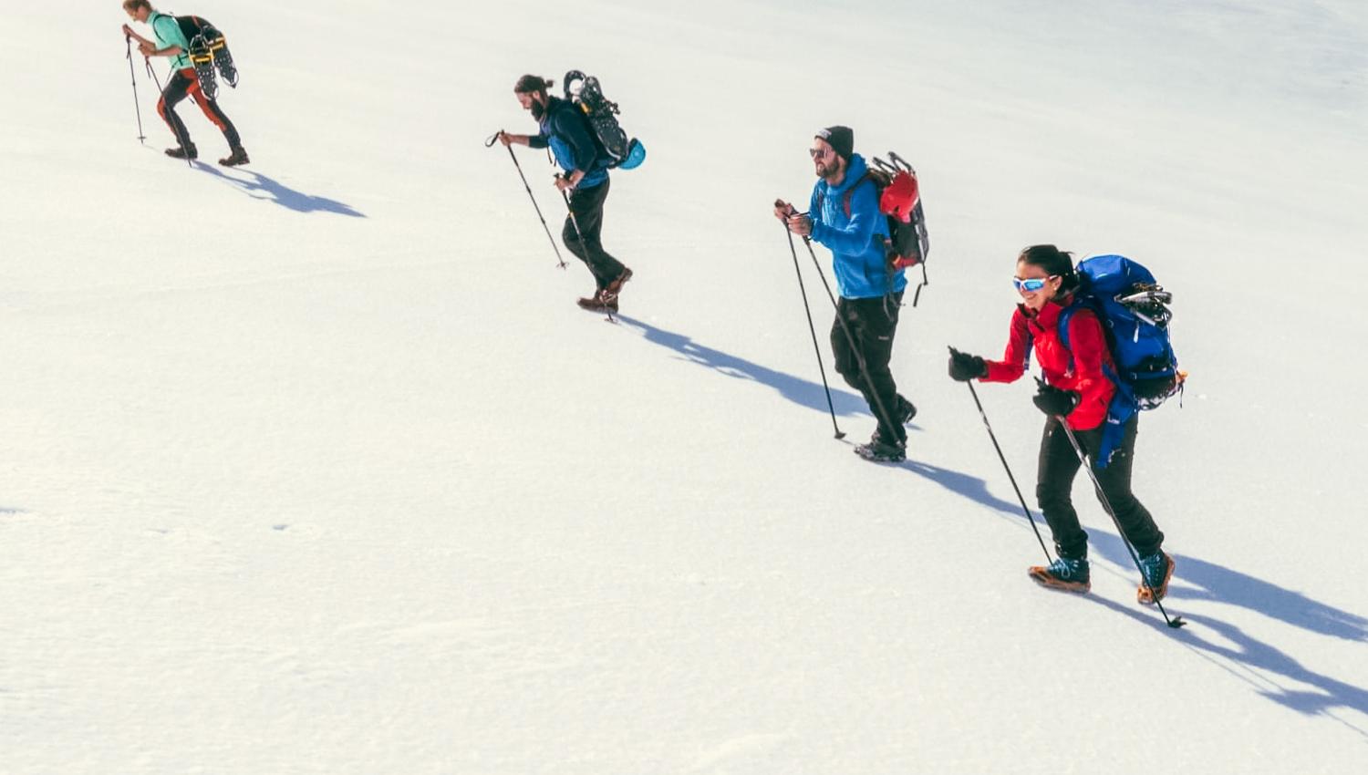 Group ascending a snowy mountainside with snowshoes near Trolltunga.