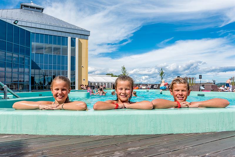 3 children look over the pool edge at the outdoor pool to Badeparken at Quality Hotel Skjærgården in Langesund 