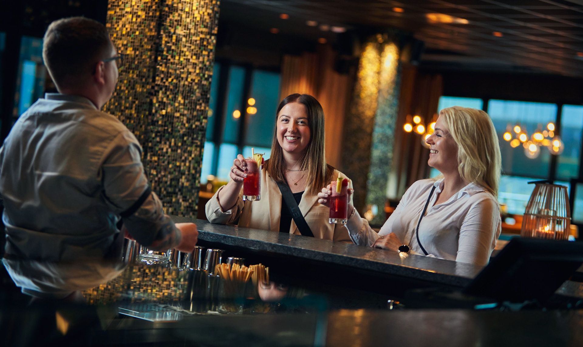 To damer nyter drikke ved bardisken