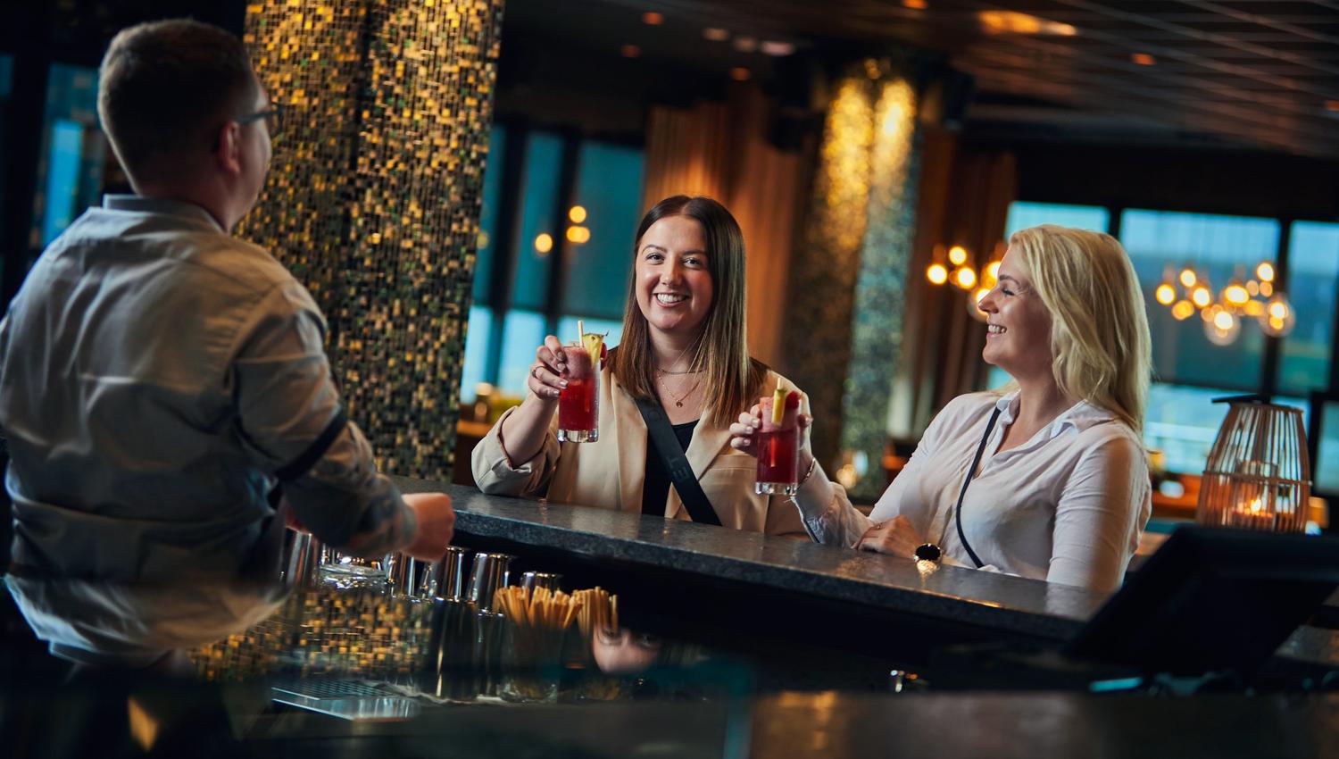 To damer nyter drikke ved bardisken