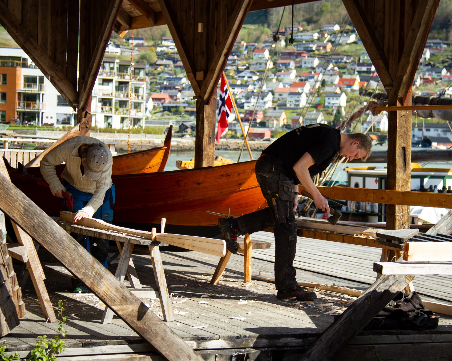 Two craftsmen working on restoring a wooden boat at Hardanger Maritime Center.