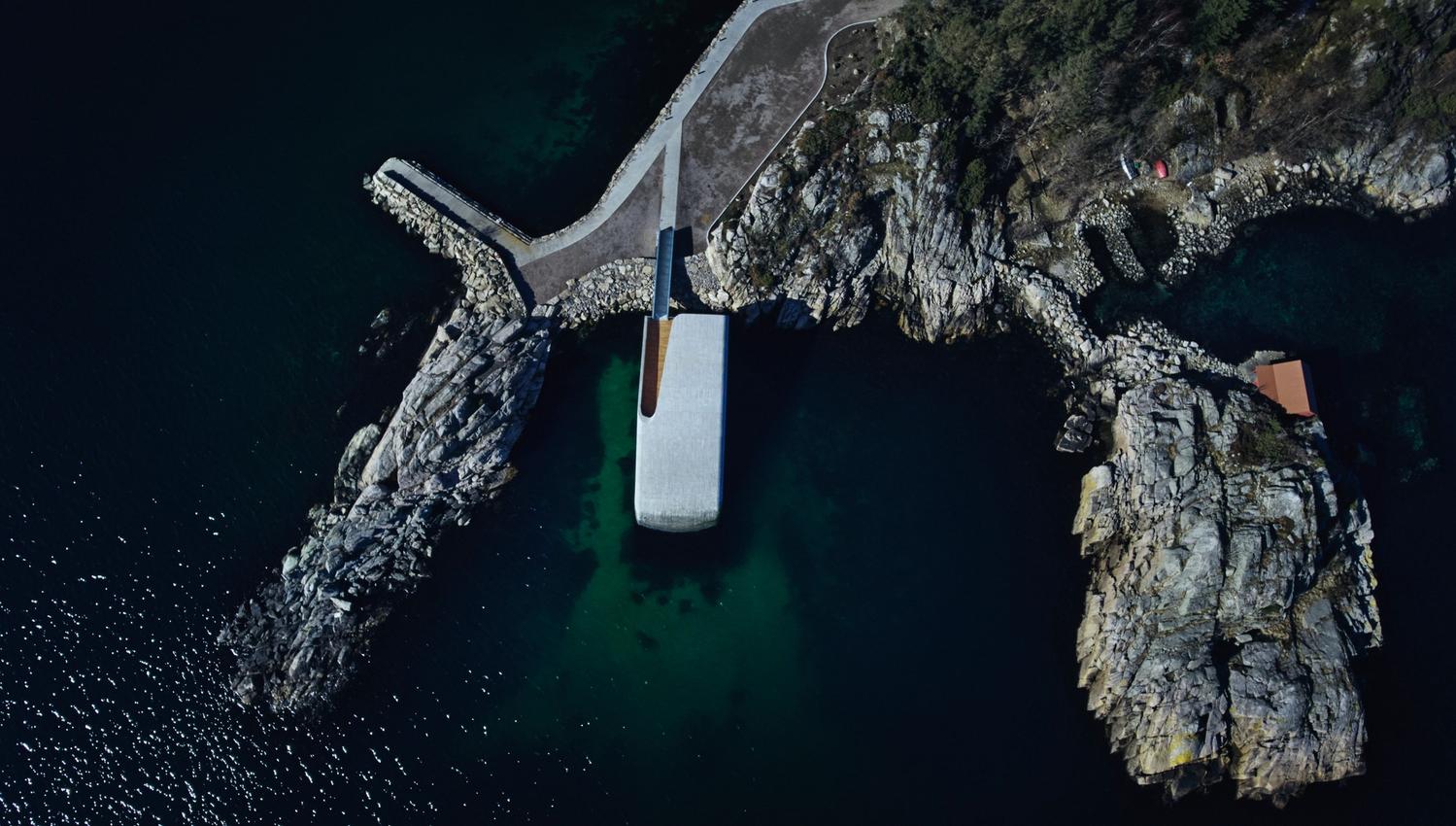 Drone shot over the restaurant UNDER and the rocky shore around UNDER.