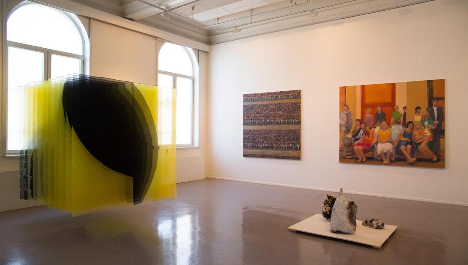 Utstilling i Kunstbanken - Kunstinstallasjon med hengende gule tråder og malerier i bakgrunnen.