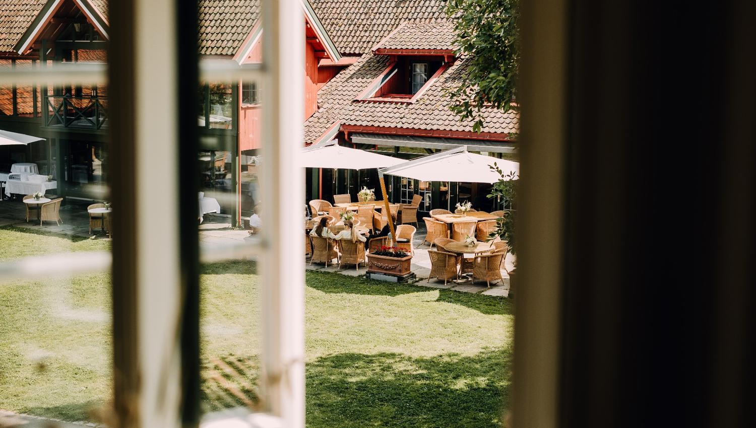 Bilde tatt fra vindu. Grønn hage.