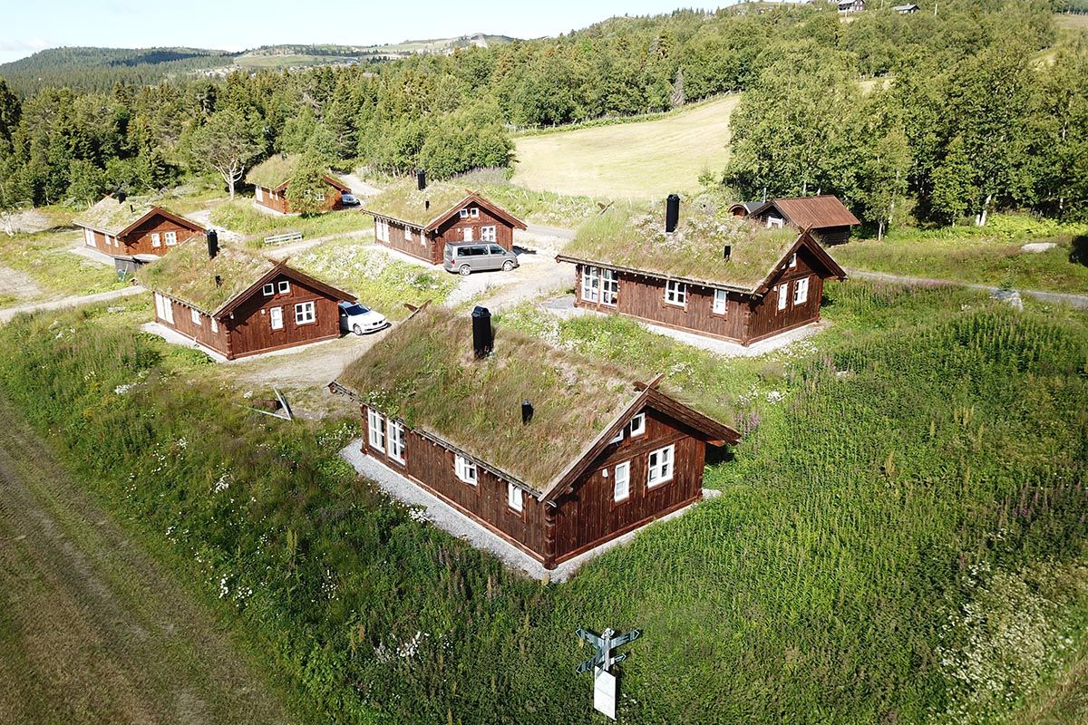 Aireal photo of a compound of six wooden huts with grass roofs