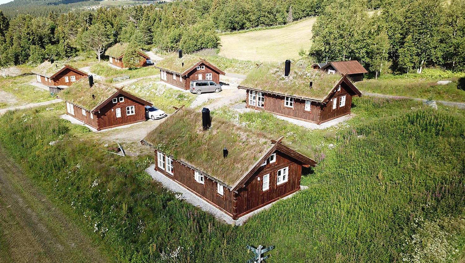 Aireal photo of a compound of six wooden huts with grass roofs
