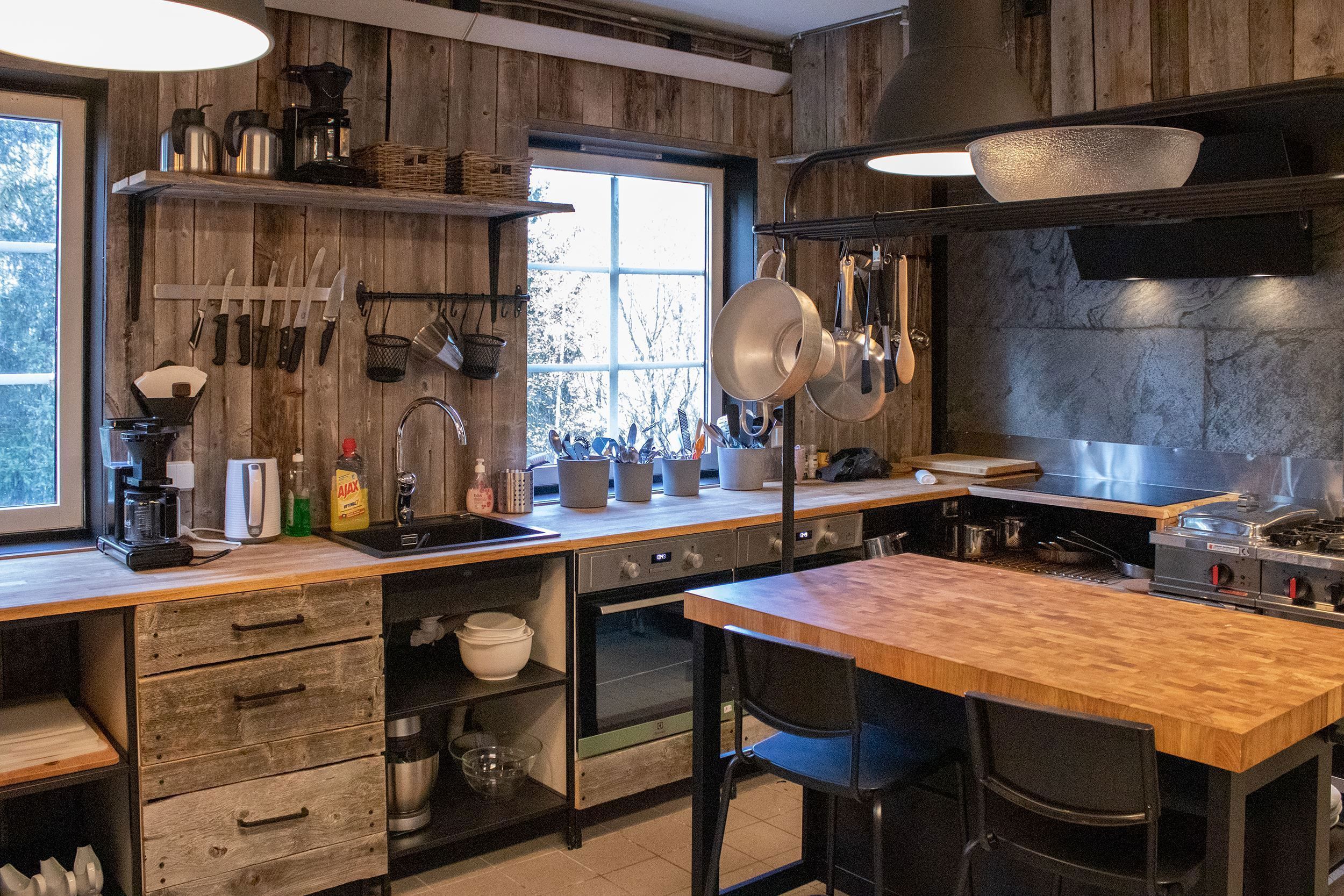 A kitchen with wooden walls and a large island.