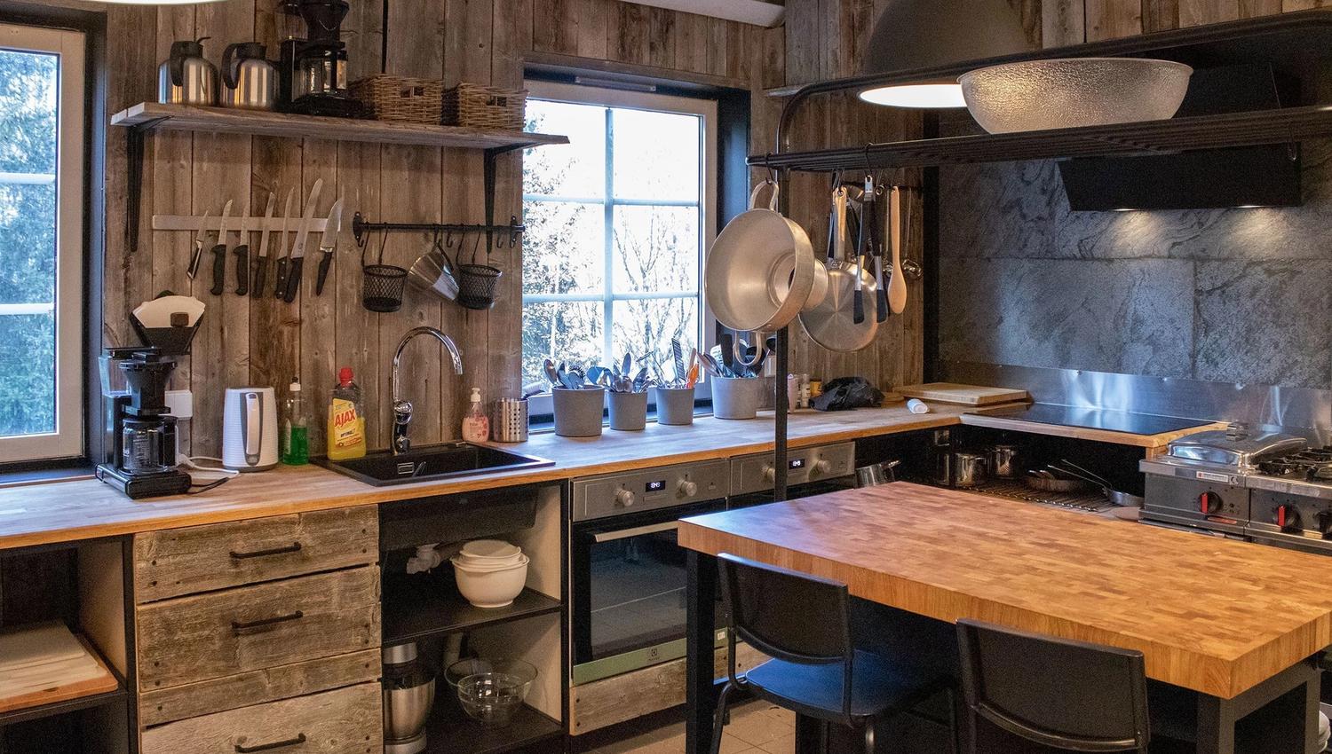 A kitchen with wooden walls and a large island.