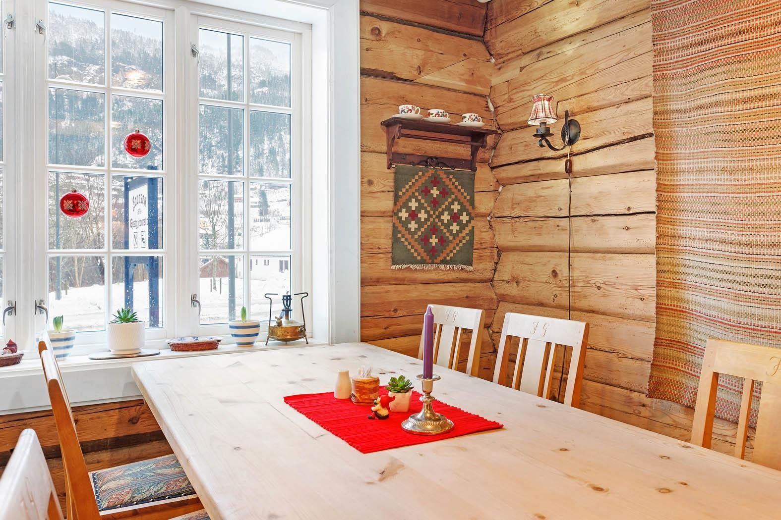 Lyst og triveleg rom med tømmerveggar og utsikt mot fjella ved Jaunsen Gjestgjevarstad.