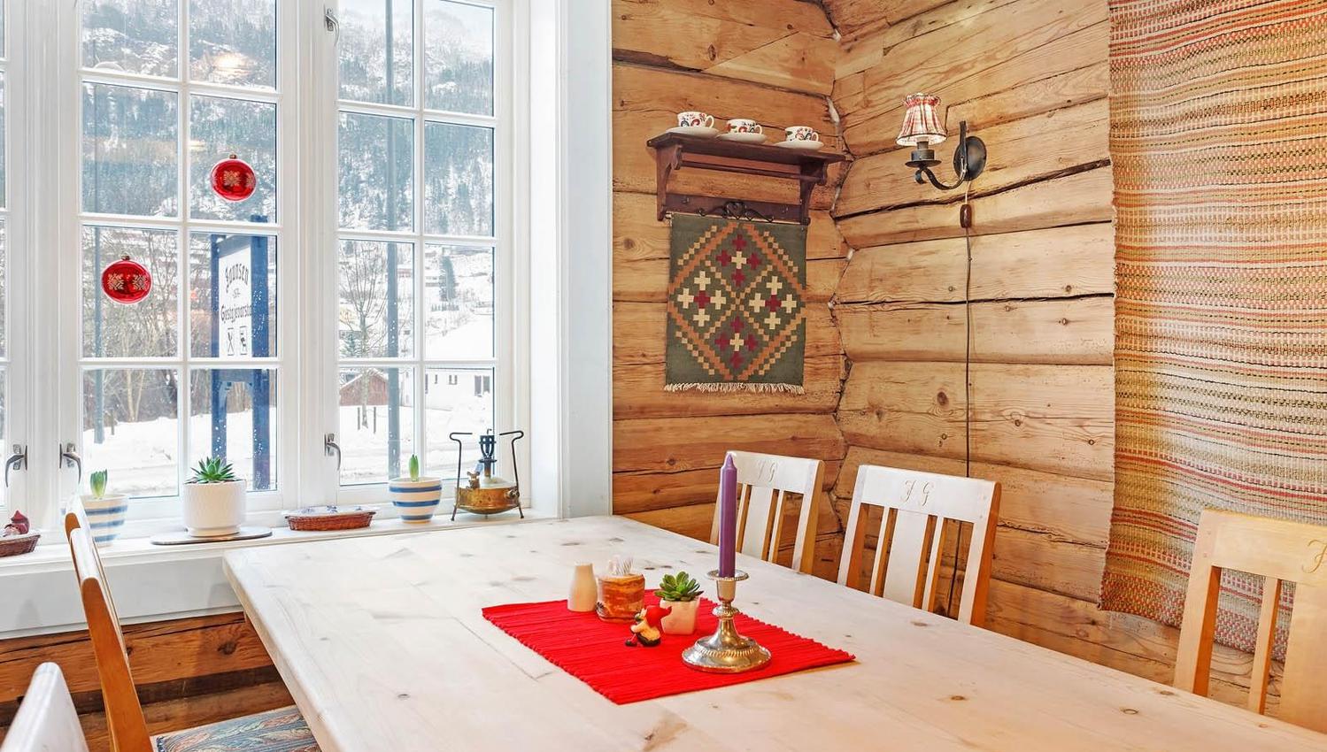 Bright, cozy room with log walls and mountain views at Jaunsen Guesthouse in Hardanger.