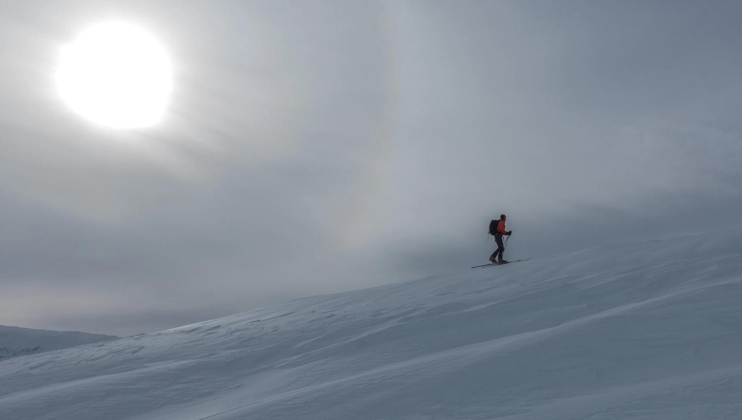 Going skiing with sun in the background