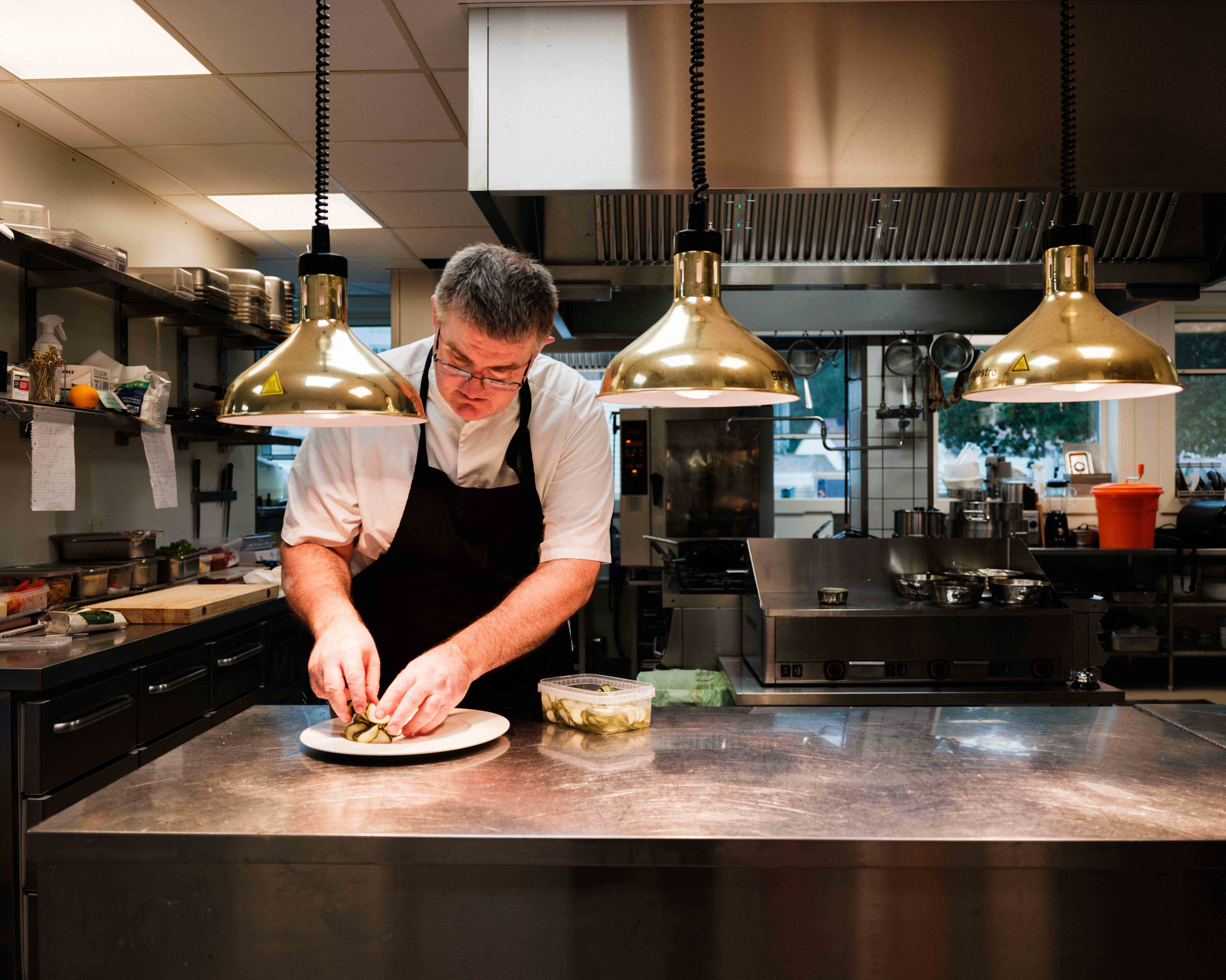 Kokken på Kinsarvik Fjordhotel legg siste hand på retten før servering.