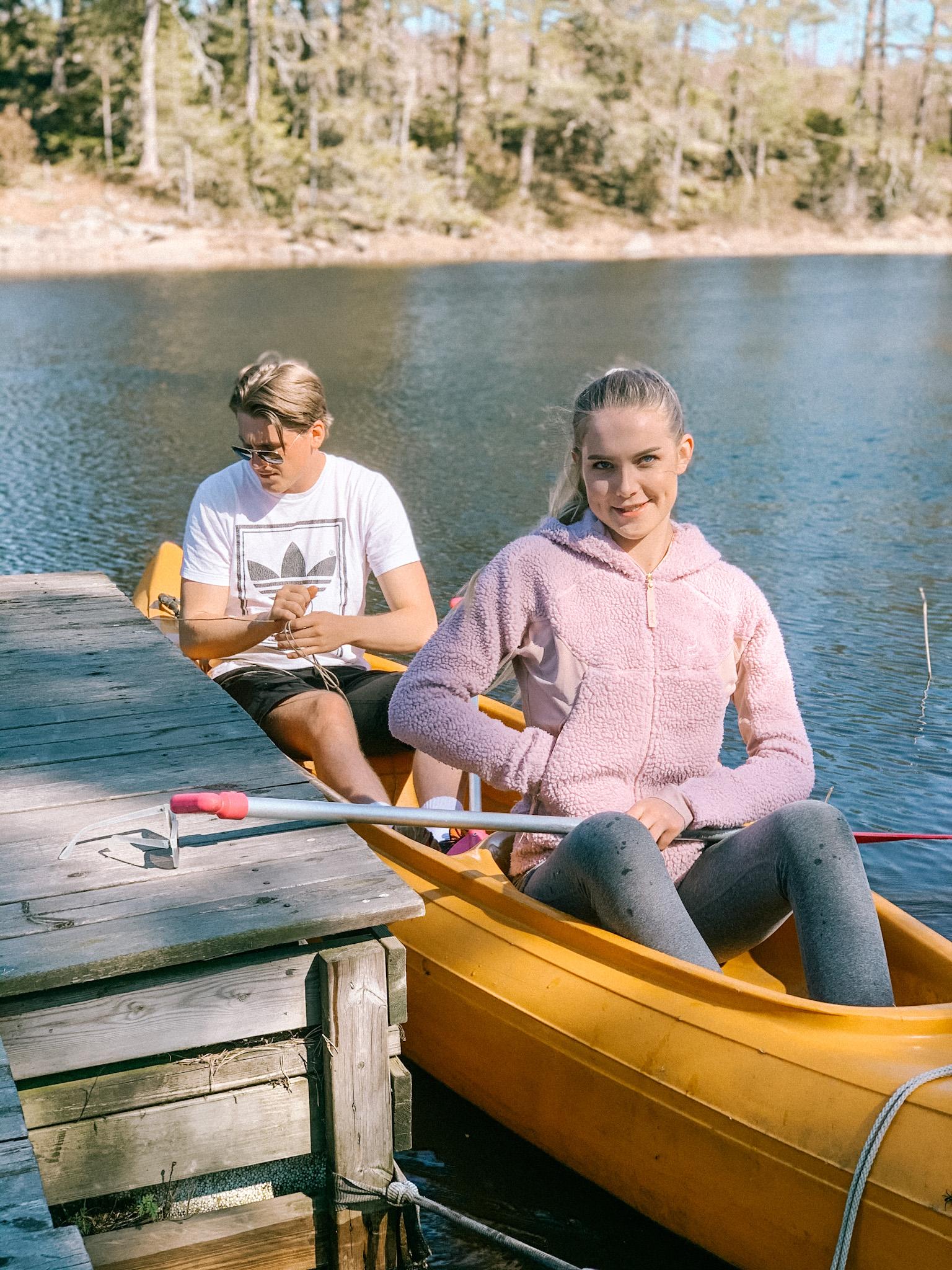 En jente og en gutt i en gul kano, ved en brygge på Børtevann. Foto.