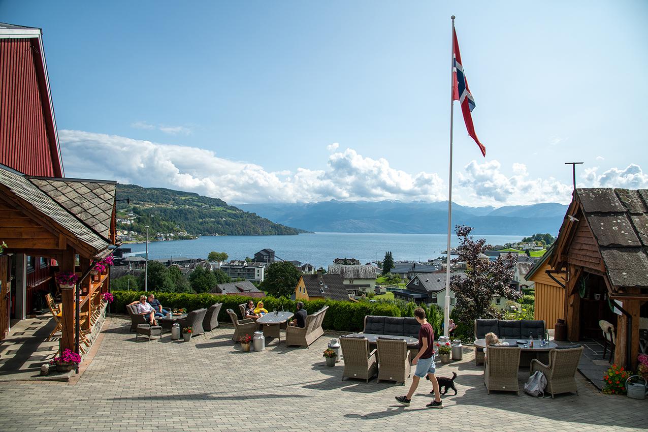 Außengastronomie im Eldhuset Hofrestaurant mit sonnigem Blick auf den Hardangerfjord.