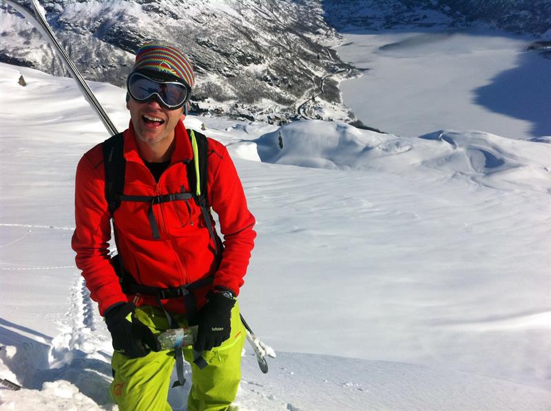 Happy skier enjoying a mountain tour in Røldal with views over the fjord and winter landscape.