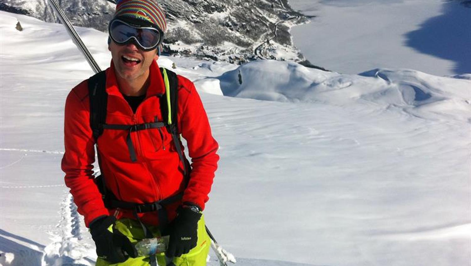 Happy skier enjoying a mountain tour in Røldal with views over the fjord and winter landscape.