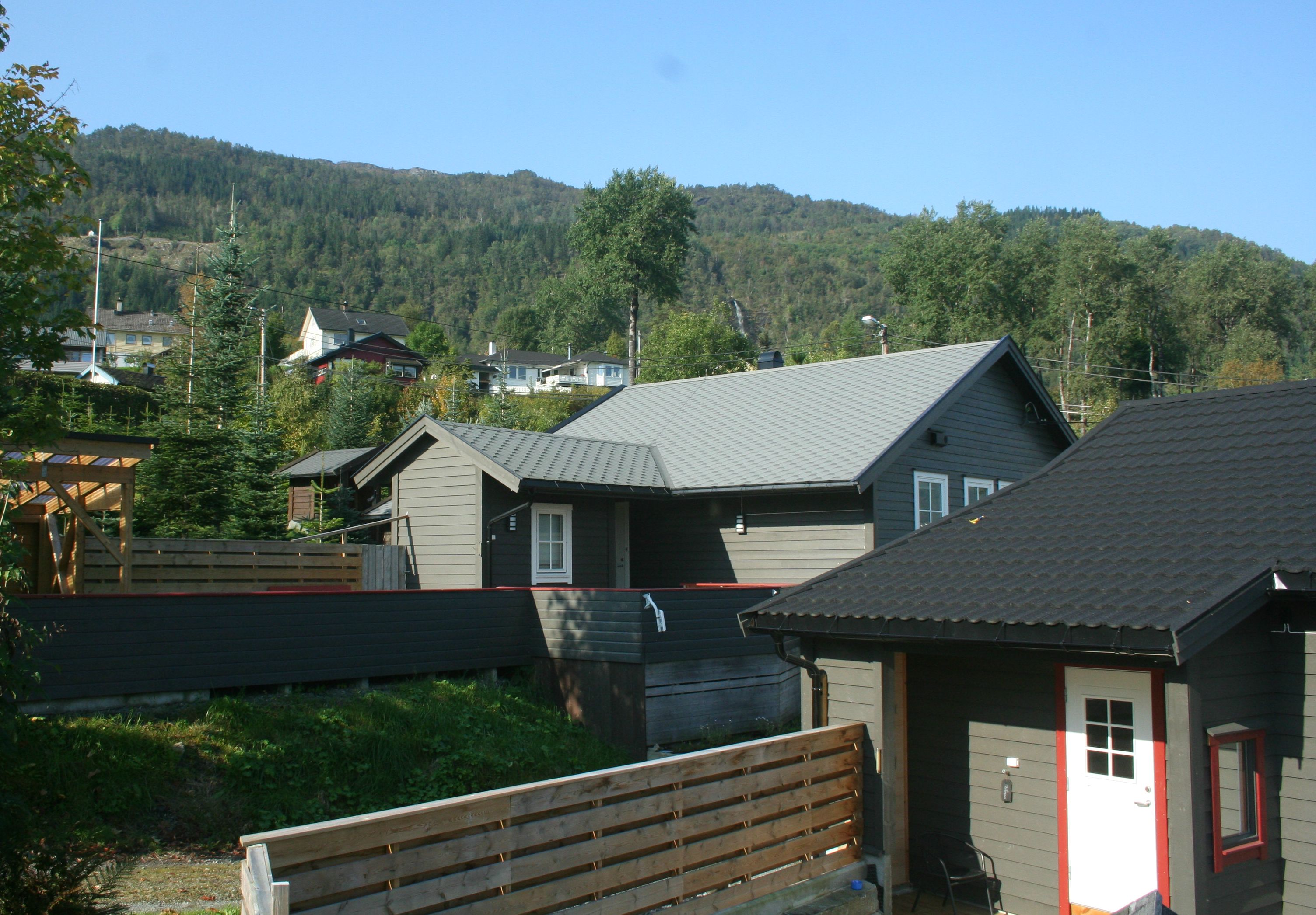 Hyttetun med moderne utleigehytter og flotte fjell i bakgrunnen ved Vågen Rom og Hytteutleige.