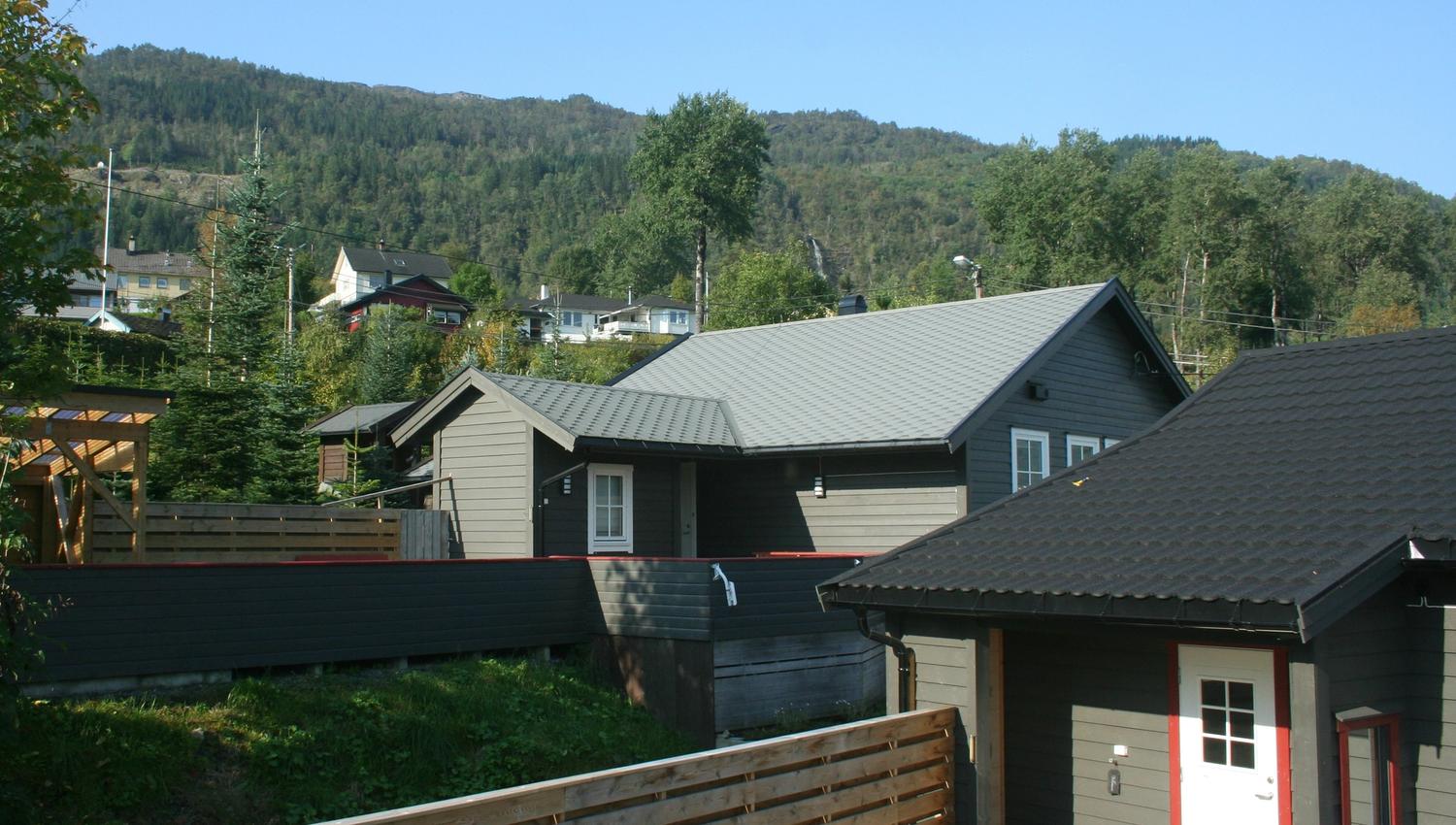 Hyttetun med moderne utleigehytter og flotte fjell i bakgrunnen ved Vågen Rom og Hytteutleige.