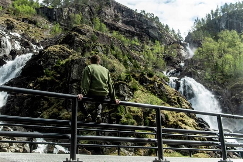 Mann nyt utsikta frå rekkverket ved Låtefoss i Hardanger, Noreg.